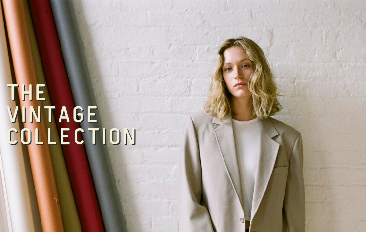 a woman in vintage suit standing in front of brick wall with caption: The Vintage Collection"