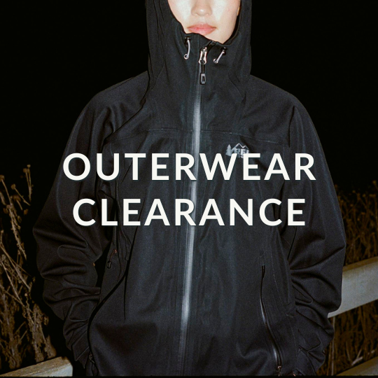 a flash photograph of someone in a black REI jacket. Caption: "outerwear clearance"